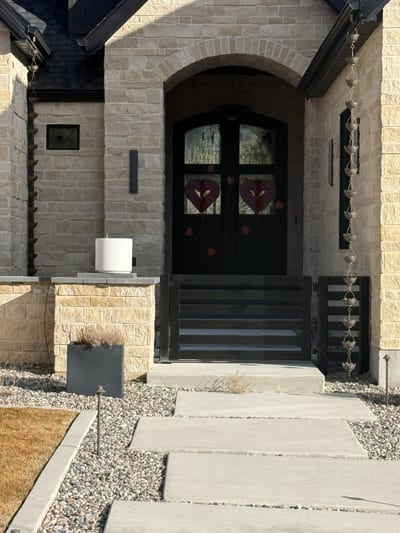 Black powder-coat steel entrance gate at a residential property.