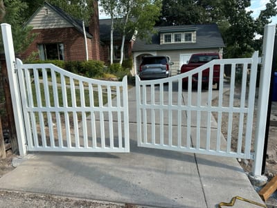 Swept-top double entry gate, 2×3 HSS frame in RAL 9002 White powder coat, installed on a residential drive in Holladay, Utah.