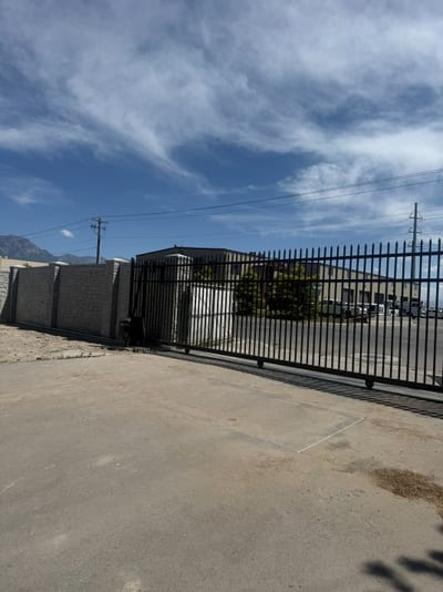 Black steel automated sliding driveway gate.