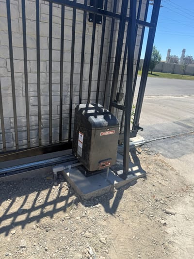 Gate operator and automation hardware on the sliding driveway gate.